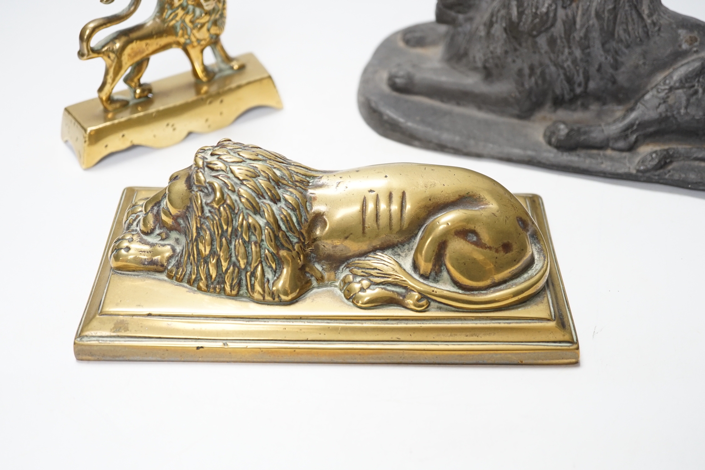 A 19th century brass recumbent lion, a similar cast iron lion and a smaller lion, largest 22cm wide